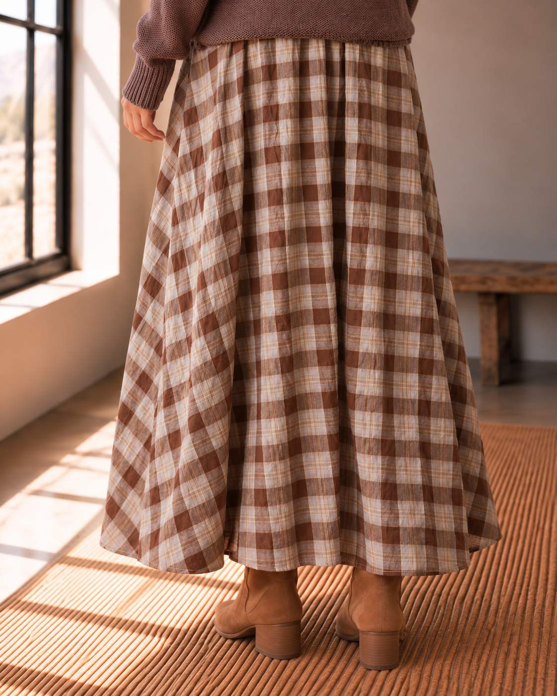 The Maplewood brown plaid cotton midi skirt with flared silhouette styled with a brown sweater and ankle boots