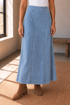 Light wash denim A line midi skirt styled with brown ankle boots, front view
