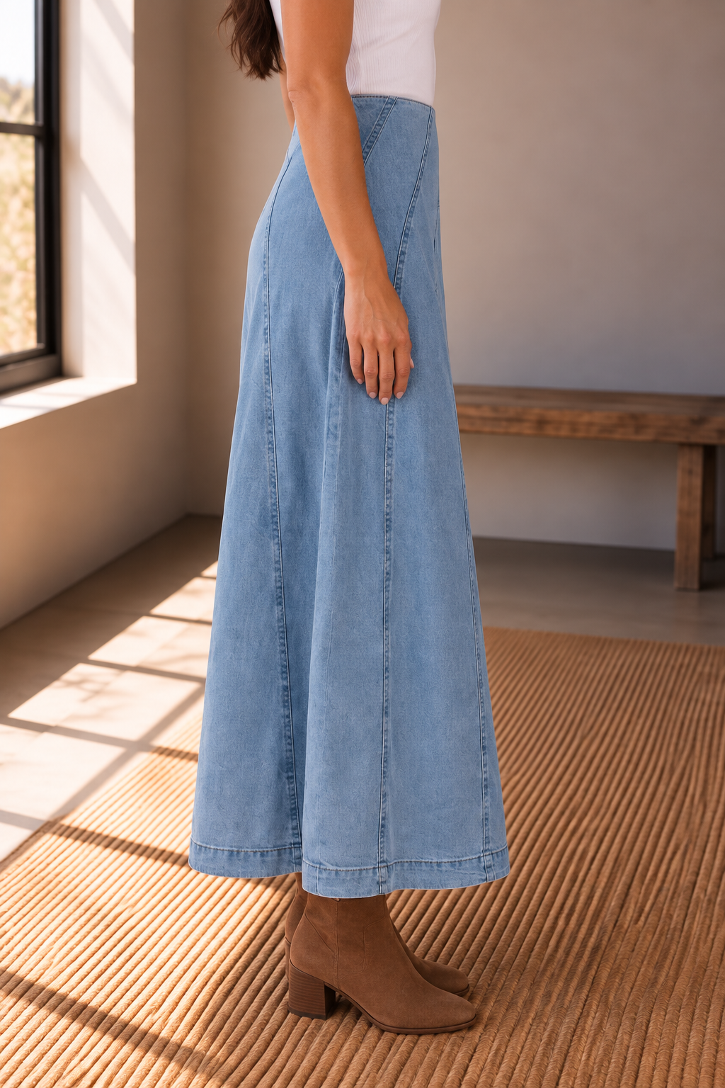 Light wash denim A line midi skirt back view showing curved paneled seams