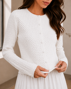 Detailed view of ivory textured knit cardigan with button front and scalloped hem